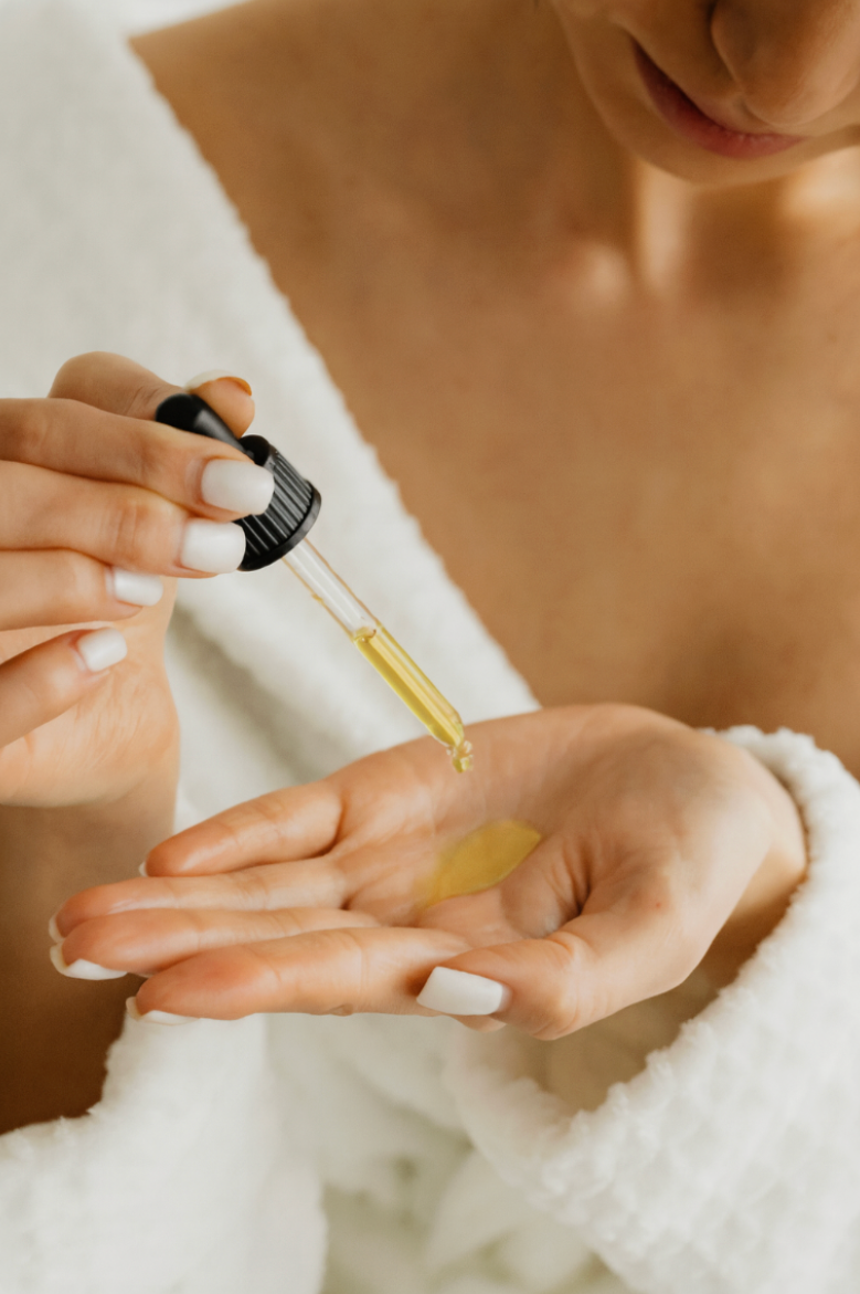 Person applying a dropper of oil to their palm
